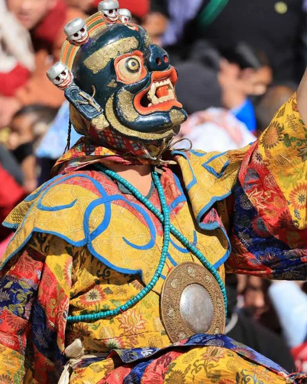 A masked Cham dancer in ceremonial headdress
